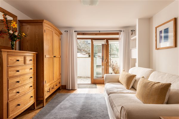 Bedroom furniture and sofa with glazed doors to terrace.